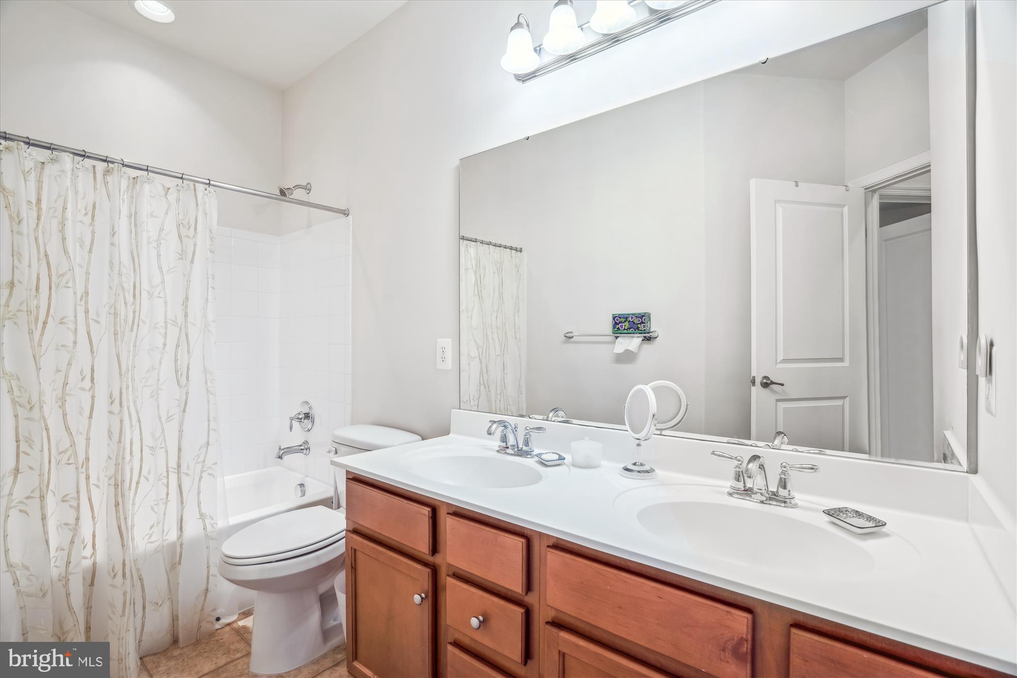 910 Hall Station Drive, Unit 202 Bowie, MD 20721 - Photo 29 of 44 a bathroom with a double vanity sink toilet and a mirror