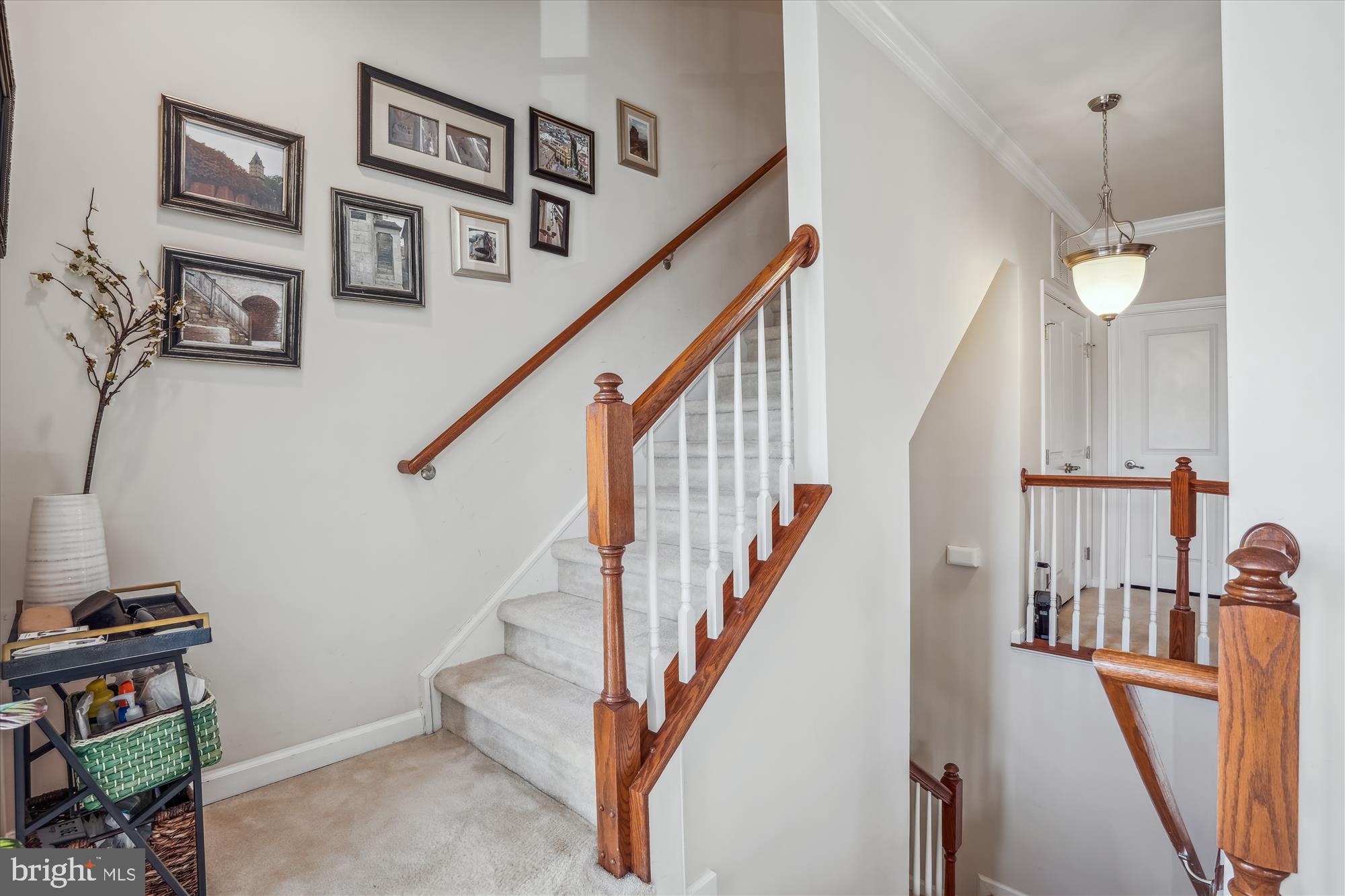 910 Hall Station Drive, Unit 202 Bowie, MD 20721 - Photo 3 of 44 a view of staircase with lots of frames on wall and a view of a living room