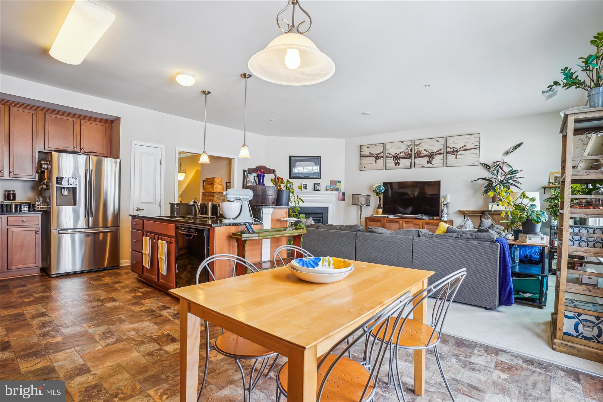 910 Hall Station Drive, Unit 202 Bowie, MD 20721 - Photo 33 of 44 a kitchen with stainless steel appliances kitchen island granite countertop a refrigerator a stove a sink dishwasher and a dining table with chairs