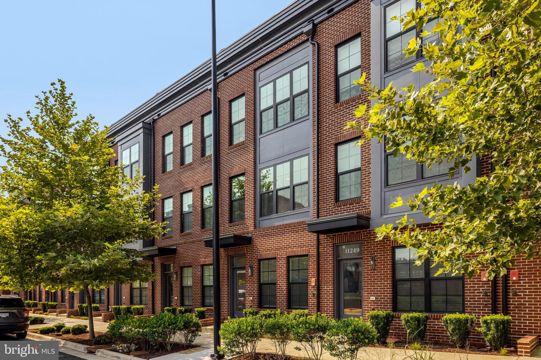 11247 Beaker Street Reston, VA 20190 - Photo 2 of 54 Modern townhomes with lush greenery.