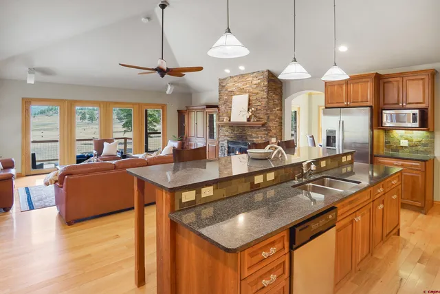 a kitchen with granite countertop cabinets a sink a stove and a chandelier