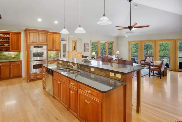 a kitchen with stainless steel appliances granite countertop a stove and a wooden floors