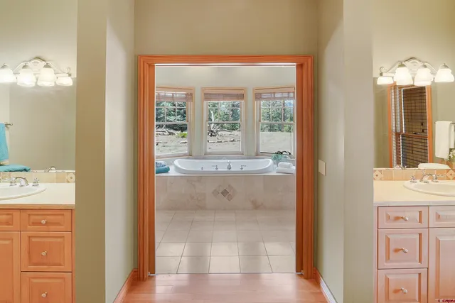 a bathroom with a tub sink and mirror