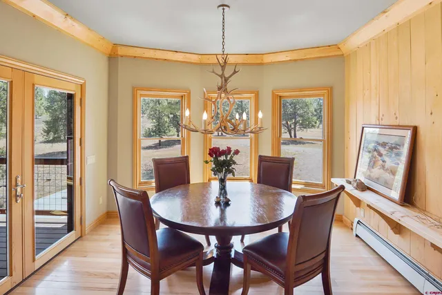 a dining room with furniture a chandelier and wooden floor