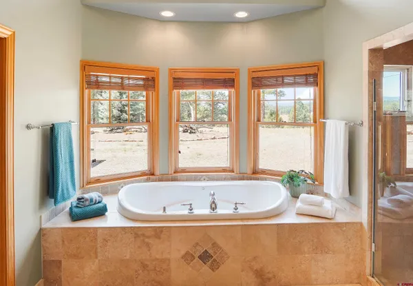 a white bath tub sitting in a bathroom next to a window