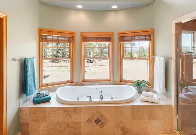 a white bath tub sitting in a bathroom next to a window