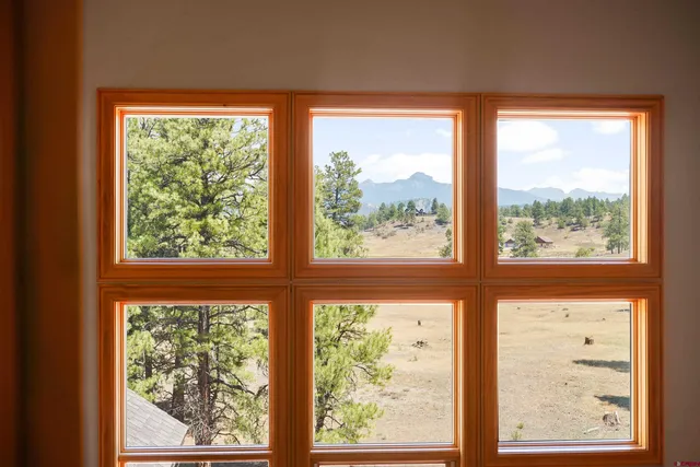 a bedroom with a bed and large windows