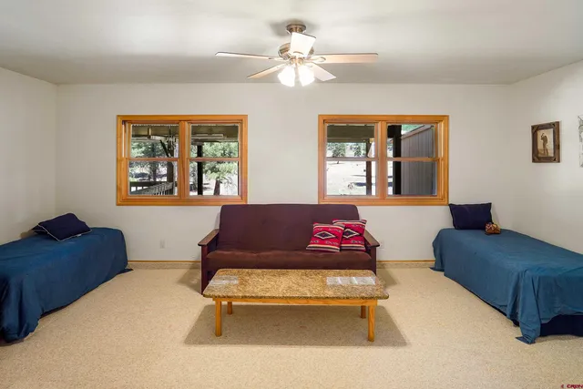a living room with furniture a ceiling fan and a rug