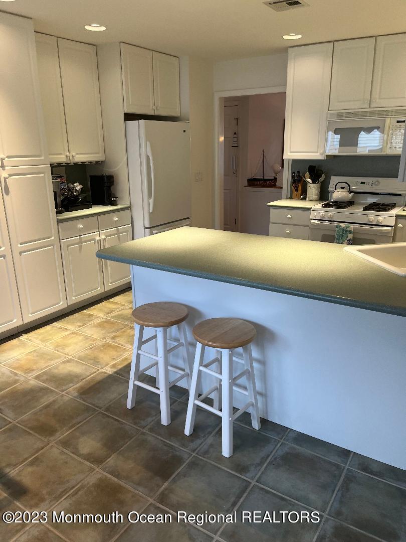 64 Van Ness Drive Brick, NJ 08723 - Photo 8 of 25 a kitchen with stainless steel appliances a stove a refrigerator and cabinets