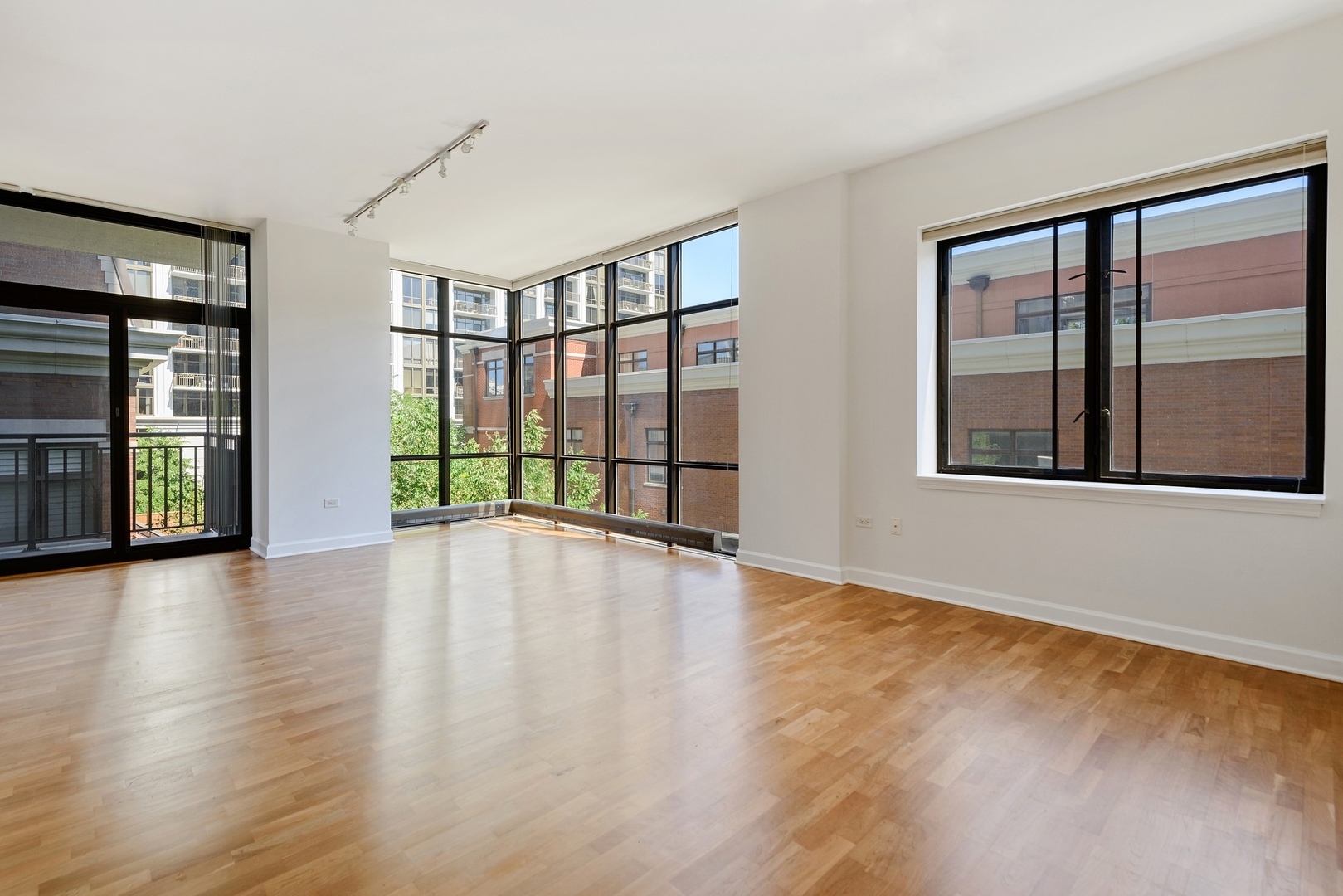 1322 South Prairie Avenue, Unit 302 Chicago, IL 60605 - Photo 2 of 13 a view of an empty room with wooden floor and a window