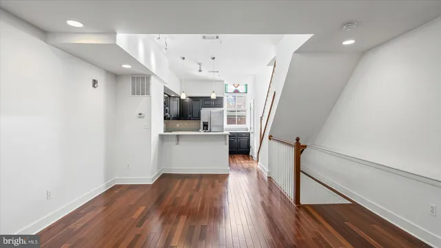 a view of a kitchen with wooden floor and electronic appliances