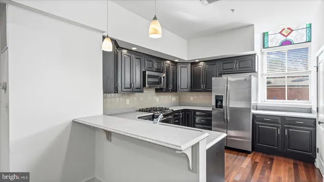 a kitchen that has a sink cabinets counter space and appliances