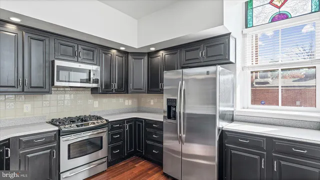 a kitchen with stainless steel appliances granite countertop a refrigerator and a stove top oven