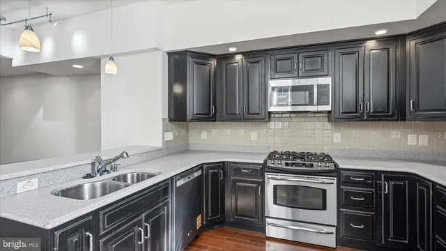 a kitchen with stainless steel appliances a stove a sink and cabinets