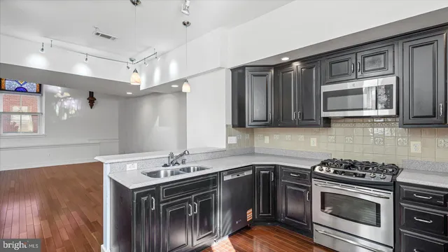 a kitchen with stainless steel appliances a stove sink and microwave