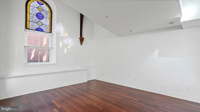 a view of an empty room with wooden floor