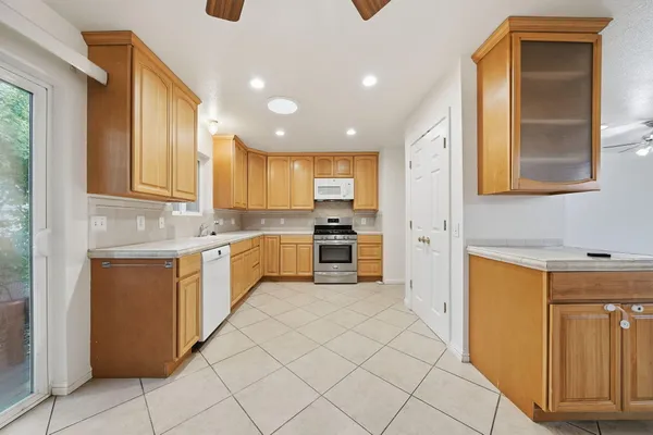 a kitchen with a sink a counter top space cabinets and stainless steel appliances