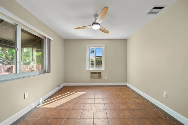 an empty room with closet and a ceiling fan