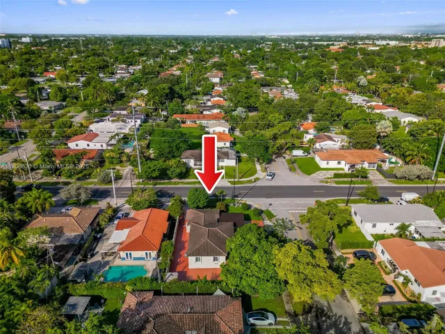 an aerial view of residential houses with outdoor space and trees