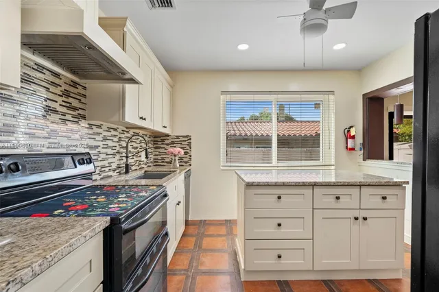 a kitchen with stainless steel appliances granite countertop a stove and a sink
