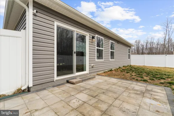 a view of house with backyard and trees in the background