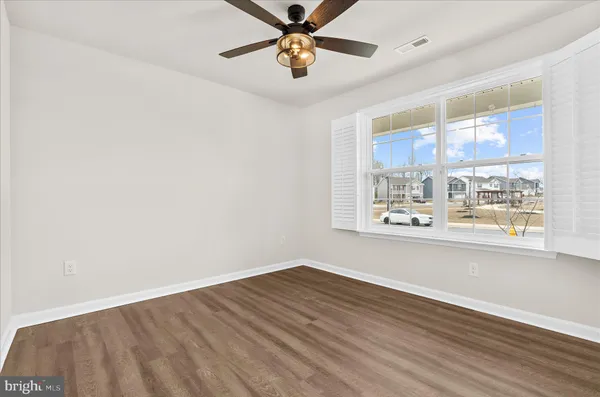 a view of a livingroom with wooden floor and a ceiling fan