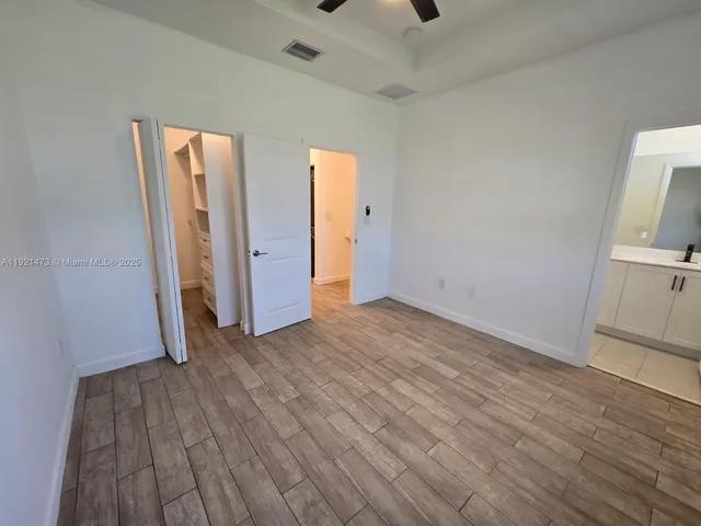 an empty room with wooden floor and closet