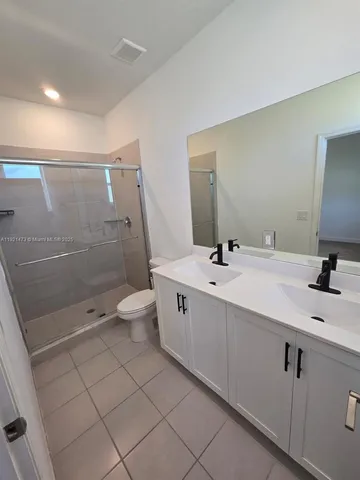 a bathroom with a double vanity sink mirror and toilet