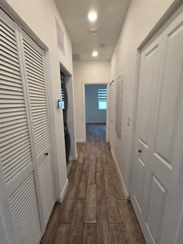 a view of a hallway with wooden floor and staircase