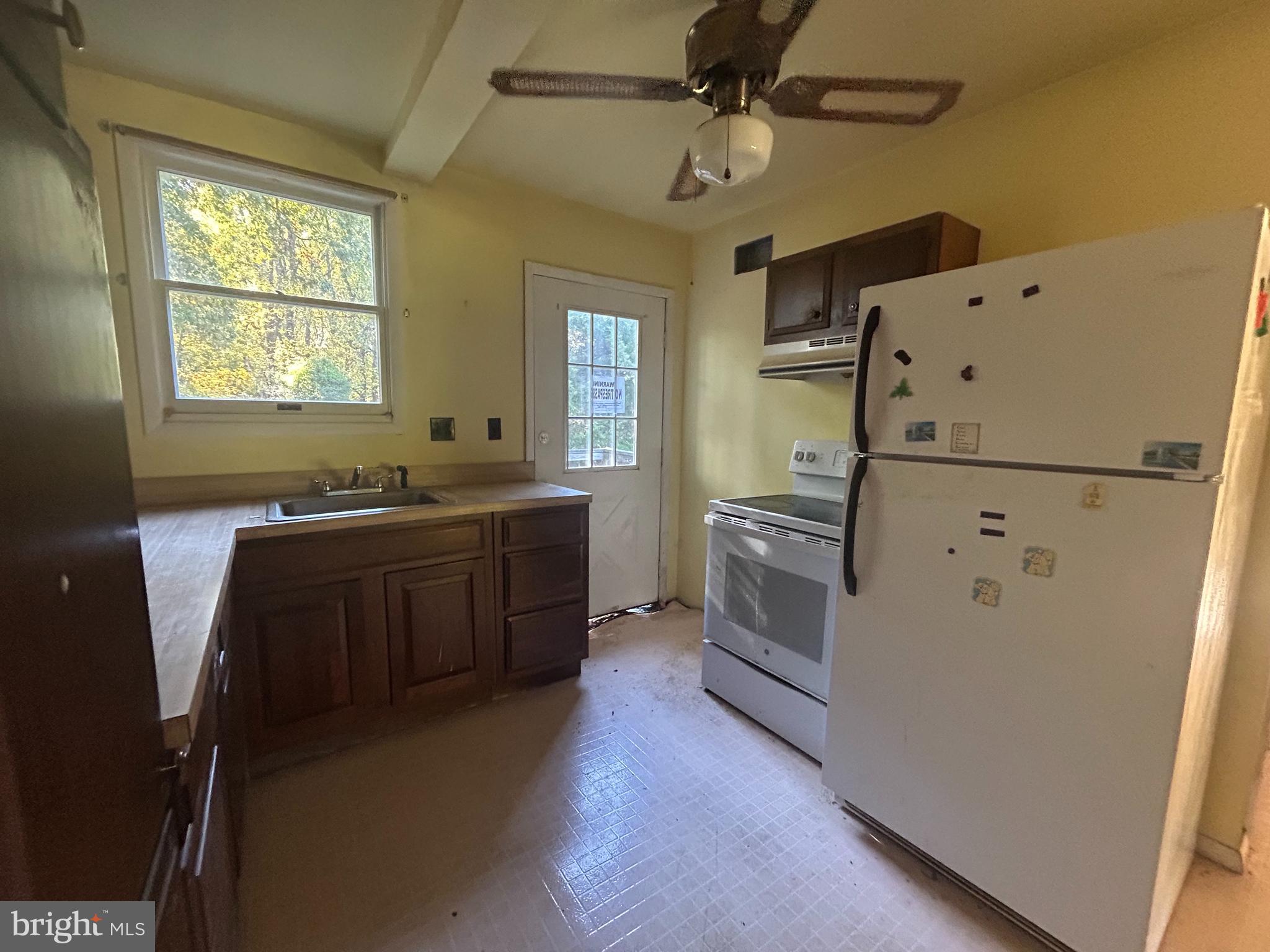15325 Holly Grove Road Silver Spring, MD 20905 - Photo 14 of 27 a kitchen with cabinets a sink and white appliances