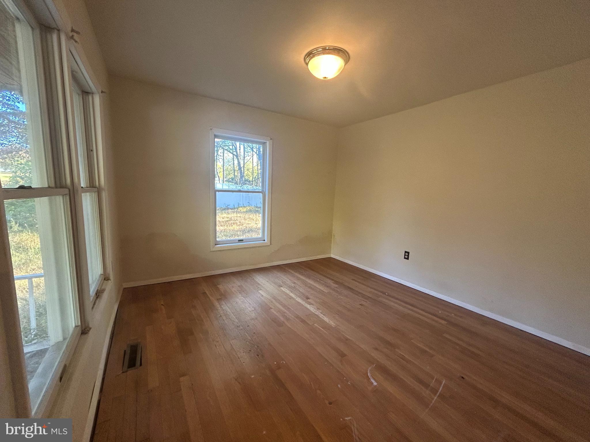 15325 Holly Grove Road Silver Spring, MD 20905 - Photo 20 of 27 an empty room with wooden floor and windows