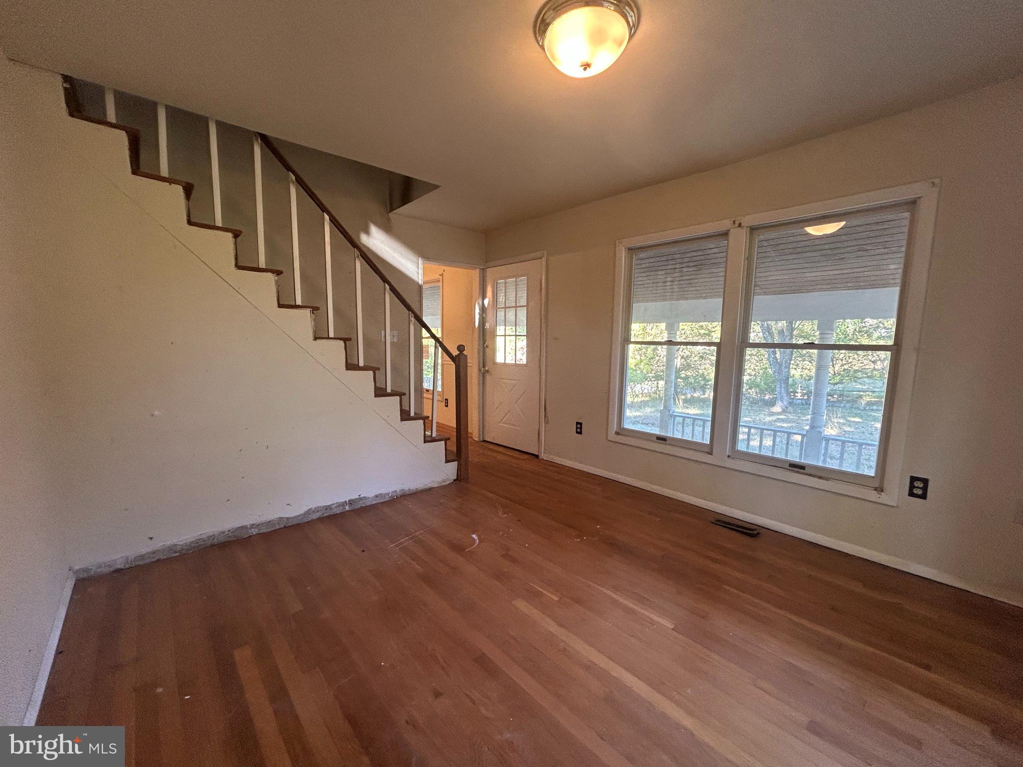 15325 Holly Grove Road Silver Spring, MD 20905 - Photo 21 of 27 a view of an empty room with wooden floor and windows
