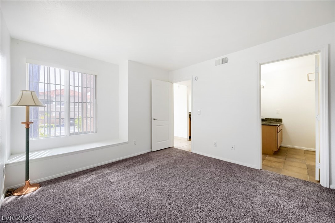 9325 West Desert Inn Road, Unit 177 Las Vegas, NV 89117 - Photo 14 of 24 A spacious bedroom with plush carpeting and a large window seat offers peaceful repose.