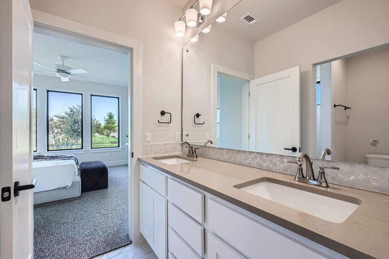 9105 Cattle Baron Path Austin, TX 78747 - Photo 5 of 29 a en suite bathroom with a granite countertop sink a large mirror and a bathtub