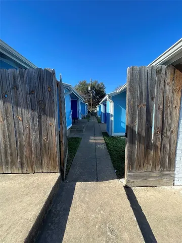 a view of a house with backyard and wooden fence