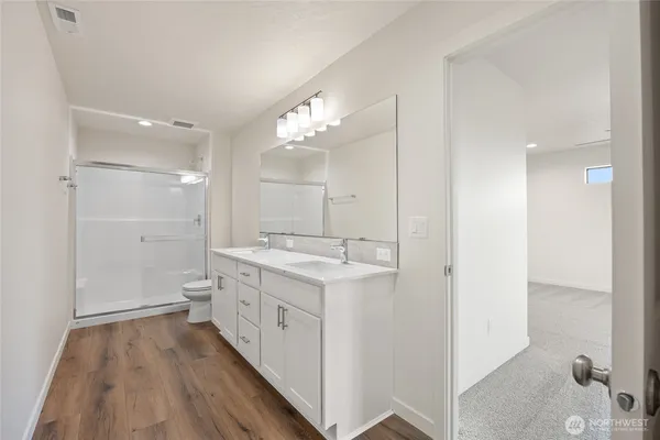 a spacious bathroom with a double vanity sink and mirror