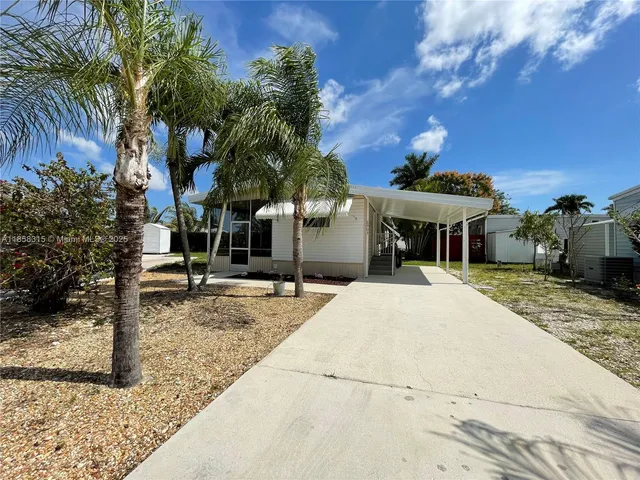 a front view of a house with a yard and parking space