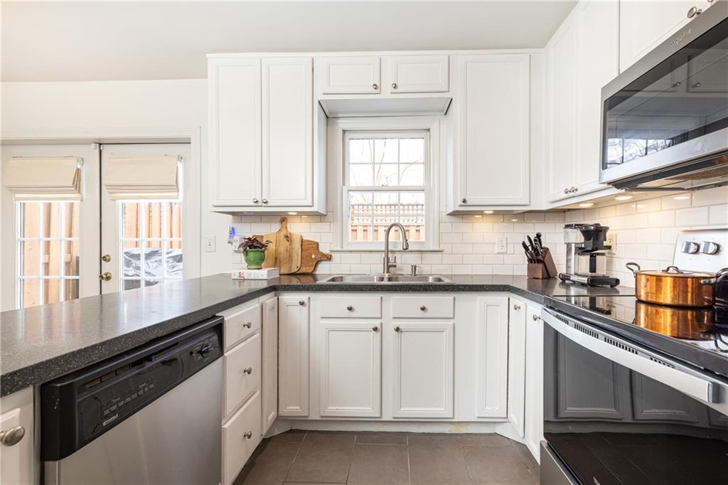 1101 Collier Road Northwest, Unit A4 Atlanta, GA 30318 - Photo 17 of 27 a kitchen with white cabinets and white appliances