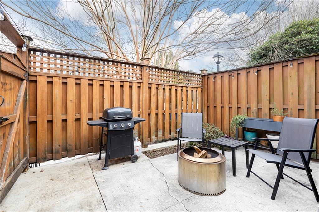 1101 Collier Road Northwest, Unit A4 Atlanta, GA 30318 - Photo 25 of 27 a view of a patio with a table and chairs potted plants with wooden walls