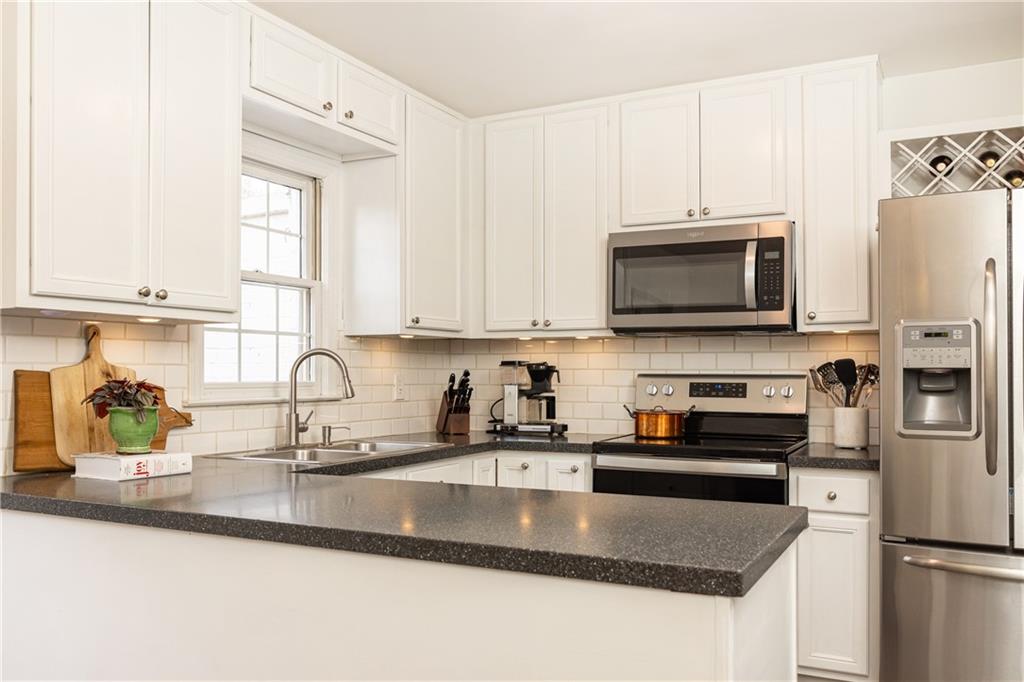1101 Collier Road Northwest, Unit A4 Atlanta, GA 30318 - Photo 10 of 27 a kitchen with stainless steel appliances granite countertop a sink a stove top oven a counter space and cabinets