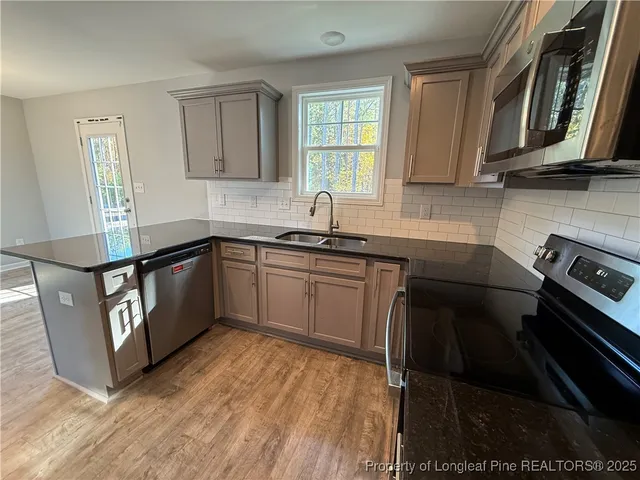 a kitchen with stainless steel appliances a sink stove and cabinets