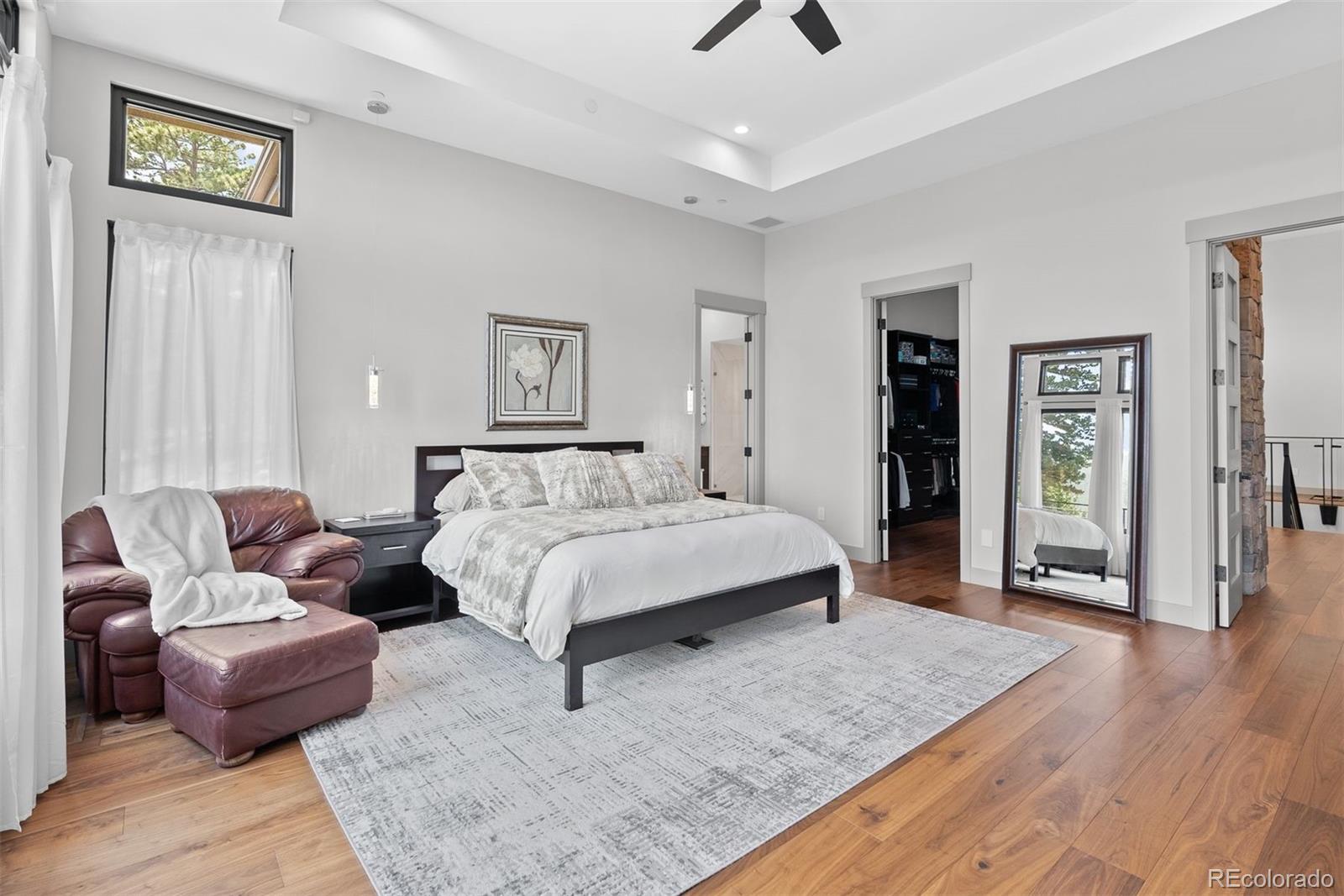 1082 West Meadow Road Evergreen, CO 80439 - Photo 23 of 50 a spacious bedroom with a bed a couch and a window