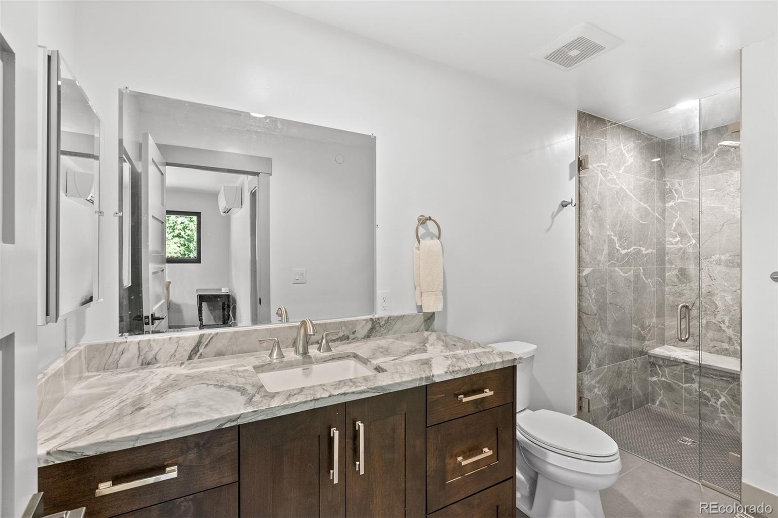 1082 West Meadow Road Evergreen, CO 80439 - Photo 42 of 50 a bathroom with a granite countertop sink toilet and shower
