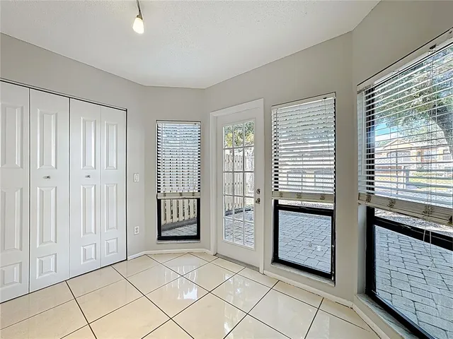 a view of an empty room with closet and a window