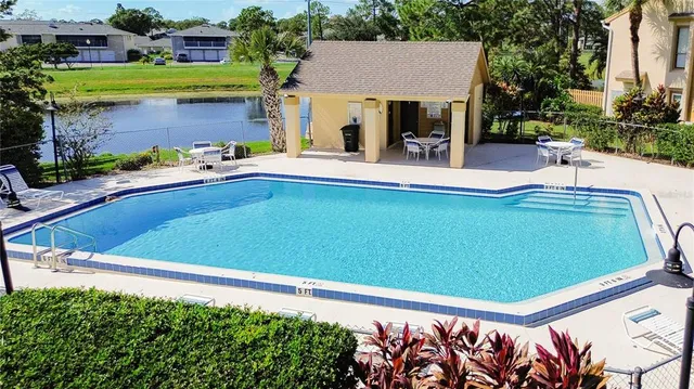 a view of a house with pool and chairs