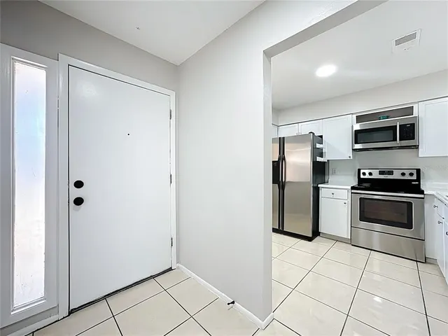 a kitchen with granite countertop a refrigerator and a stove top oven