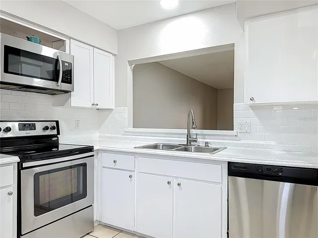 a kitchen with a sink stove and microwave