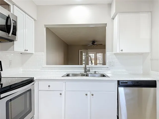 a kitchen with stainless steel appliances granite countertop a sink and a stove