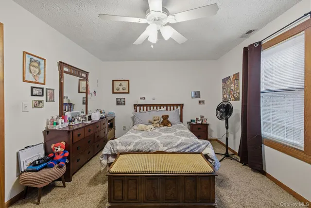a bedroom with a bed and a flat tv screen on dresser