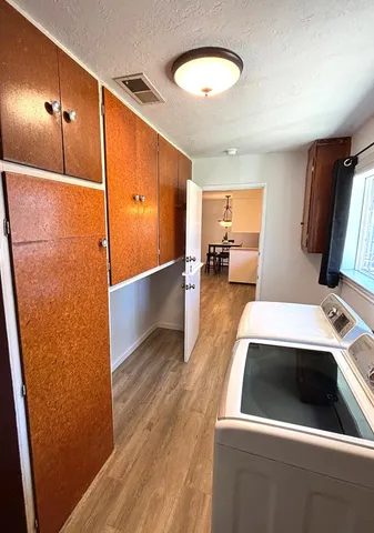 a utility room with wooden floor washer and dryer